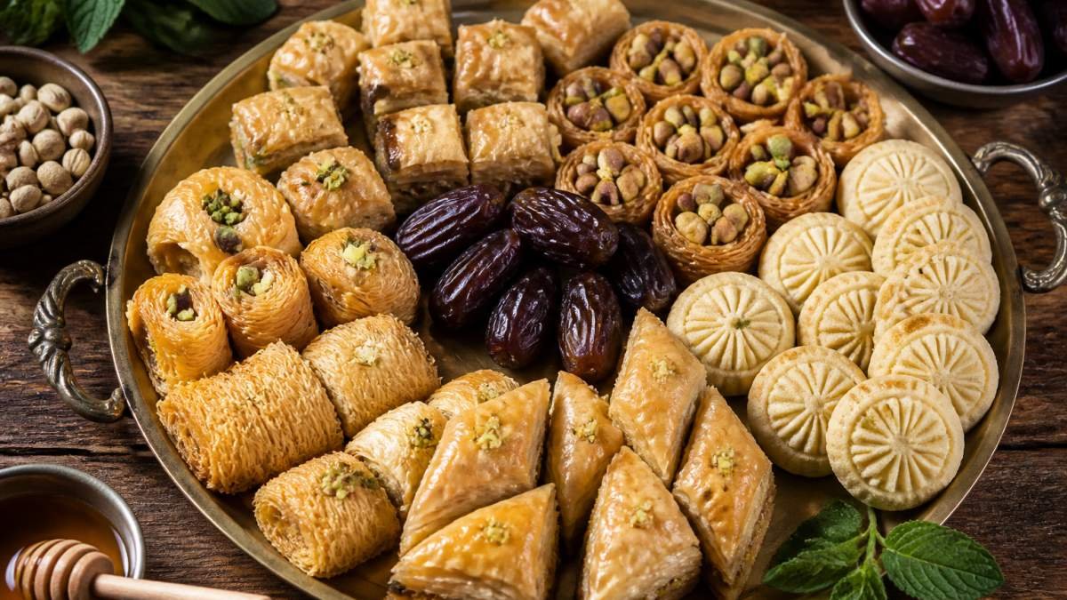 Assorted traditional Middle Eastern sweets like baklava and maamoul on a rustic wooden tray for those who buy Middle Eastern
